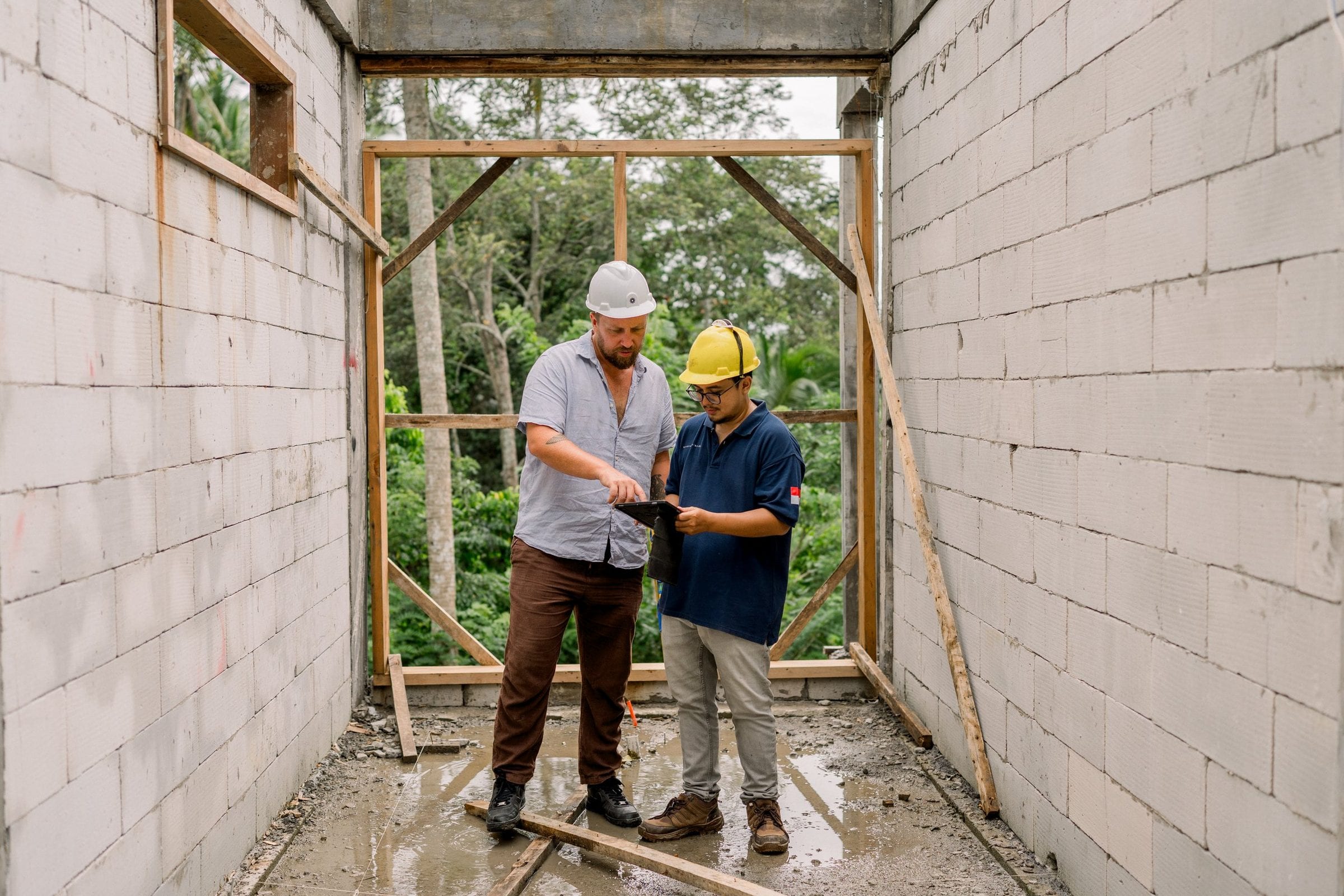 Pak Nick and a project manager reviewing plans on iPad inside a Nirvana Islands build